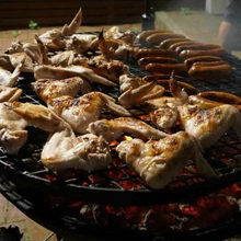 Load image into Gallery viewer, Cooking sausages and chicken wings on the Ultimate BBQ Fire Pit