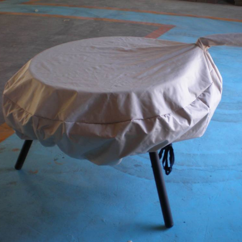 Waterproof Vinyl Fire Pit Cover on an Ultimate BBQ Fire Pit, sitting on a cement floor.
